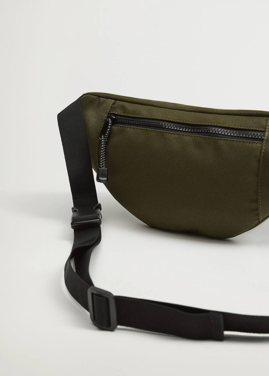 Mango Canvas belt bag with zipper. a close-up of the waist bag's zippered pocket. 