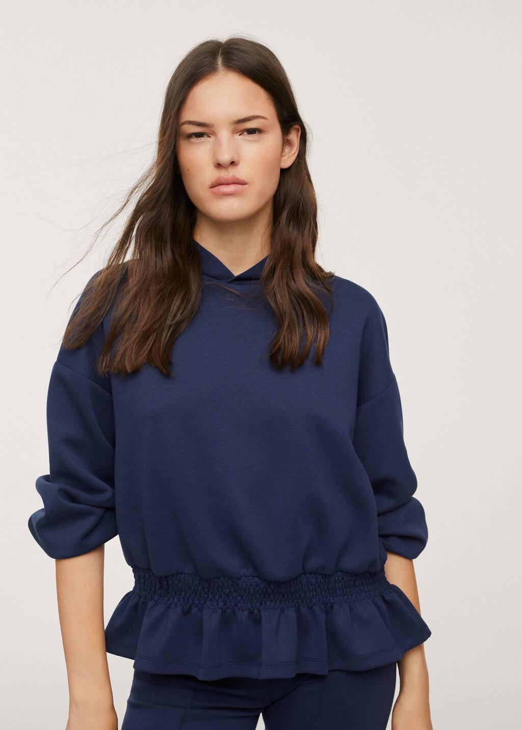 Mango Stretch hoodie. a woman wearing a blue sweatshirt and a black skirt. 