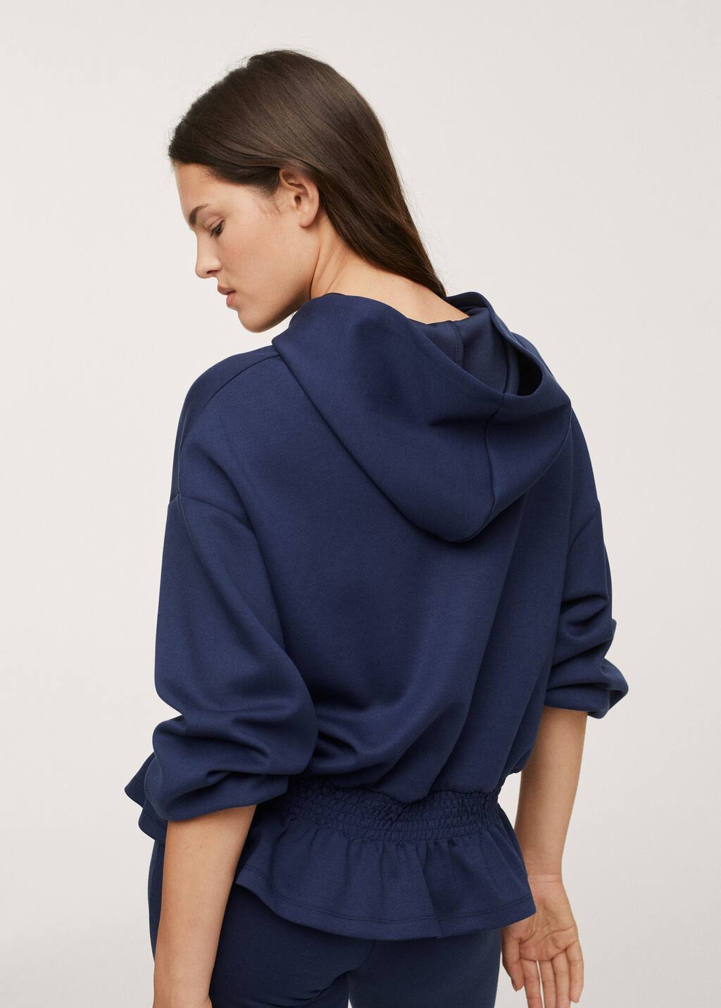 Mango Stretch hoodie. a woman wearing a blue sweatshirt and a black skirt. 