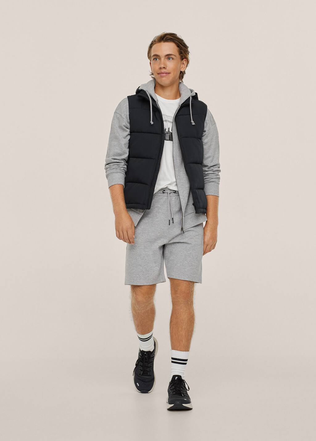 Mango Jogger cotton Bermuda shorts. a young man wearing a black vest and gray shorts. 