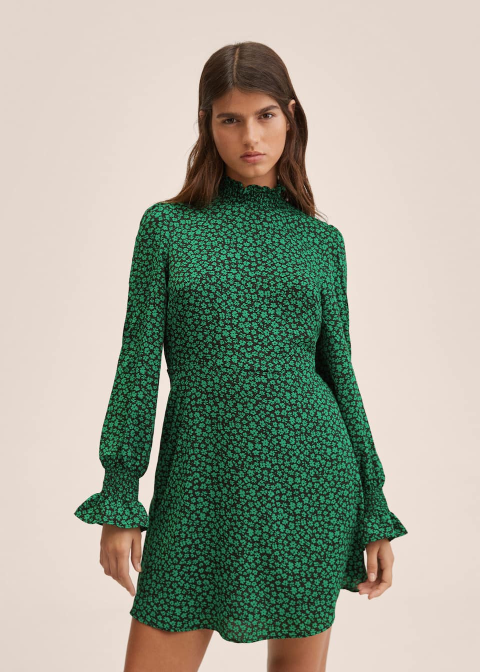 Short baby doll dress with fluted elasticated sleeves, high shirred collar and nipped in waist. Black base with green ditsy floral print.