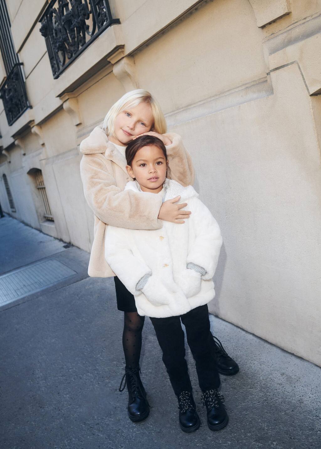 Mango Lapels faux fur coat. two young girls posing for a picture on the sidewalk. 