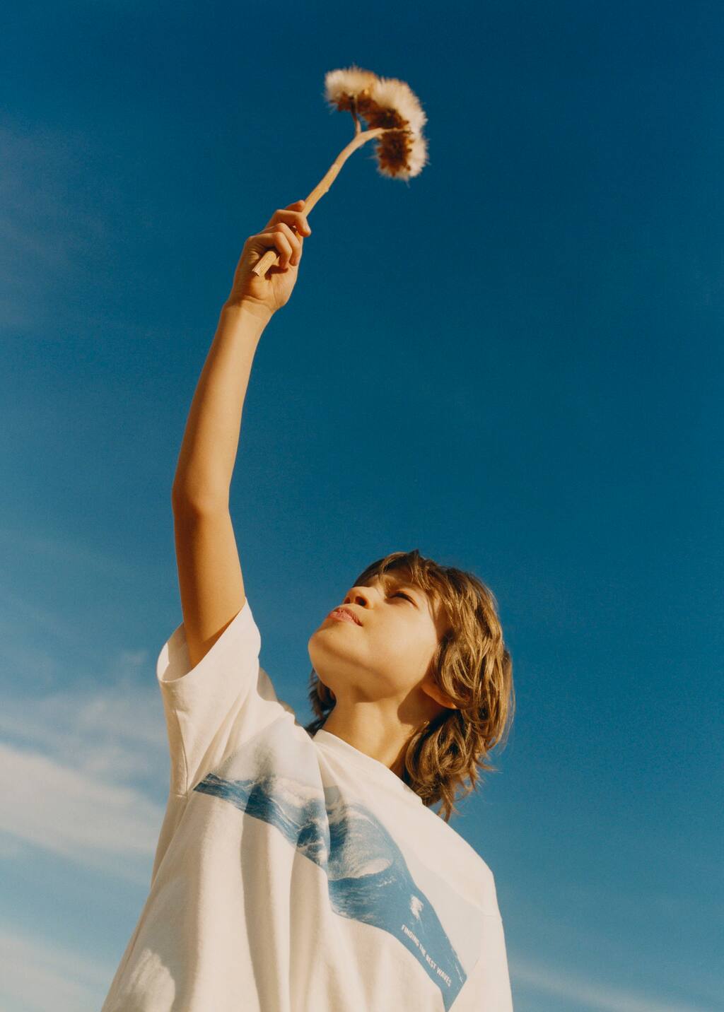 Mango Printed cotton-blend T-shirt. a young boy holding onto a stick with something in it. 