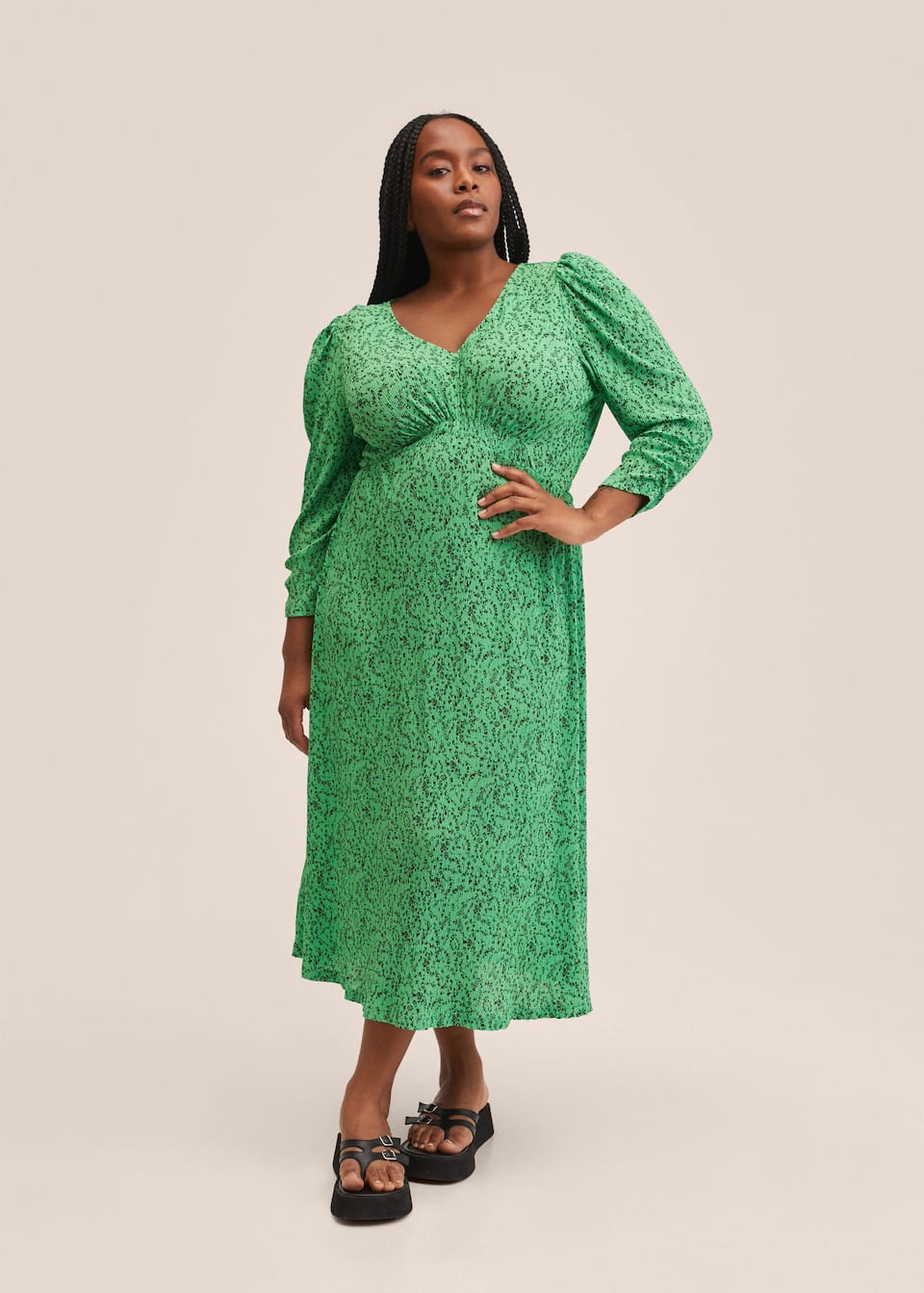 Mid length pleated fabric dress in bright green with subtle black floral print. V neck, fitted under the bust and wrist length gathered sleeves.