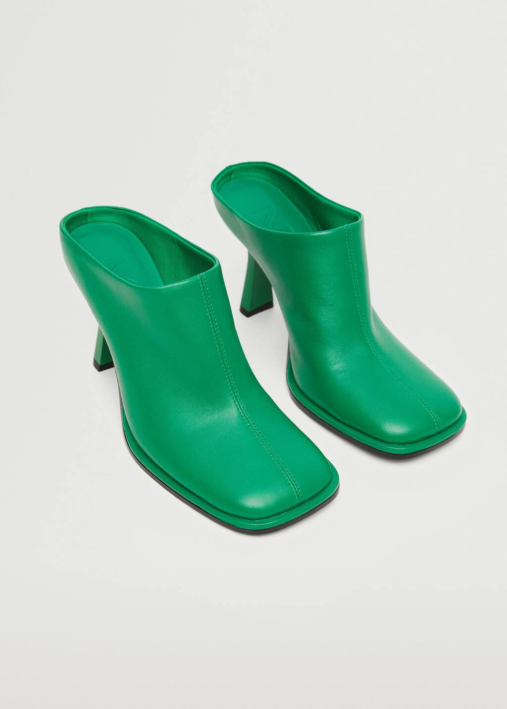 Mango Sling back leather shoes. a pair of green high heeled mules sitting on top of a table. 