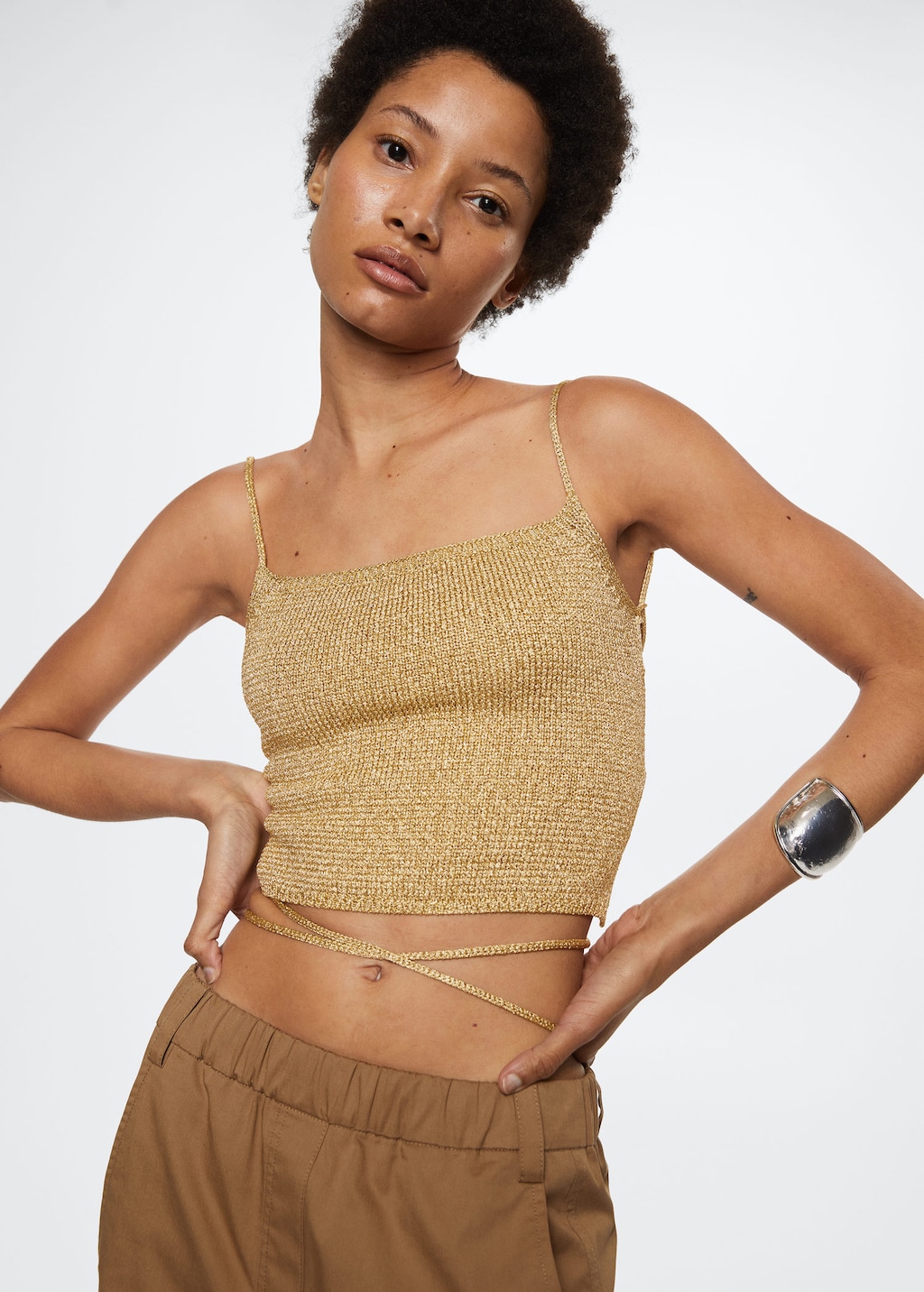 Gold metallic knitted Recycled polyester blend top in a cropped design with thin straps and an open back with strap zig zag fastening.