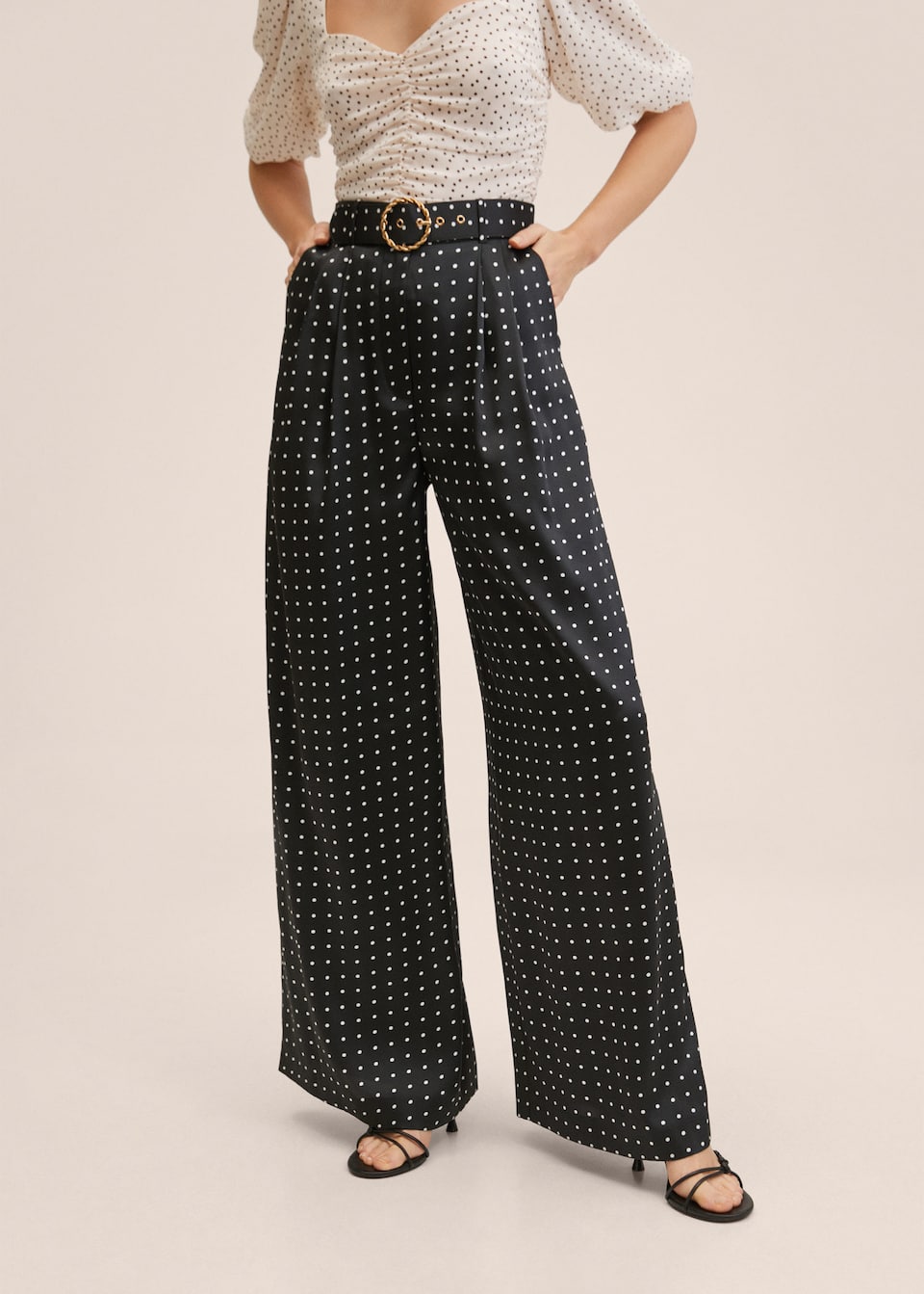 Wide Satin palazzo pants in a black and white polka dot print with matching belt detail with round metal buckle.