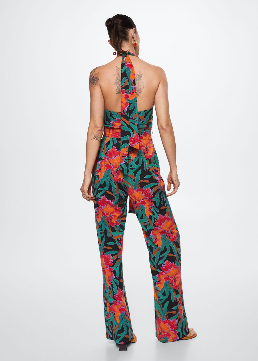 Mango Floral print jumpsuit. a woman wearing a floral jumpsuit is standing. 