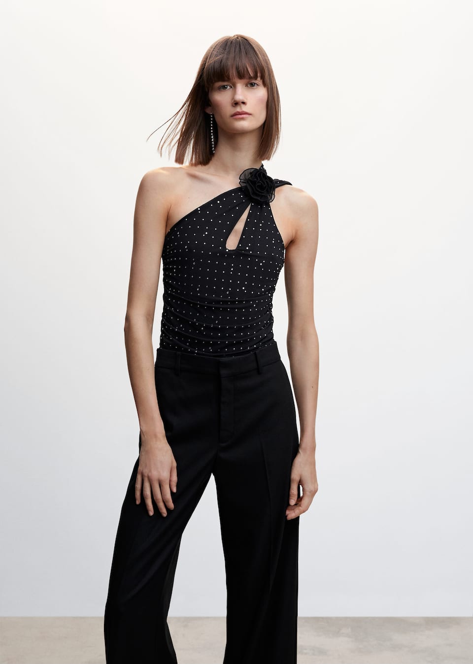 Mango black body with cross over straps and keyhole detail at the chest. Rhinestone details and tonal black floral corsage detail at the neck.