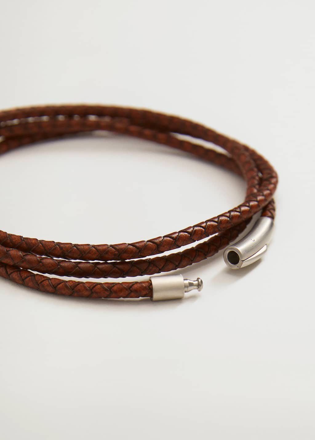 Mango Braided leather bracelet. a close-up of a brown leather cord with a silver clasp. 