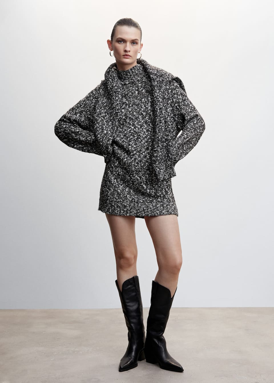 Mango thick knitted mini dress in a speckled black and white knit fabric. Short design in a relaxed loose fit with mock neck and long sleeves.