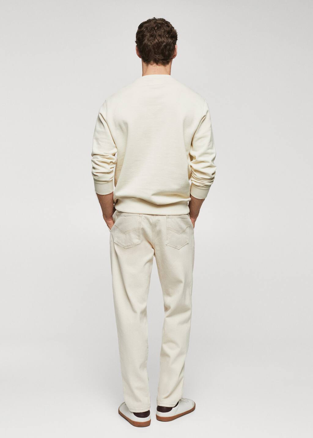 Mango 100% cotton sweatshirt text. a man standing in front of a white wall. 