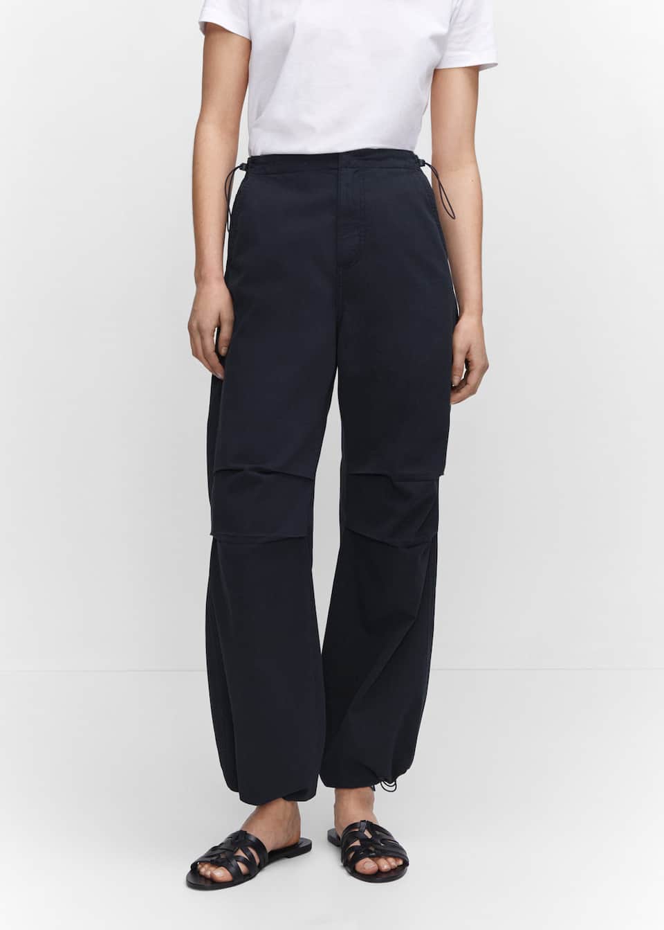 An easy way to wear the parachute pant trend Mango's 100% cotton pair come in a flowy fabric with a Medium rise waist with inner adjustable elastic toggle fastening as well as a Concealed zip and button fastening. Two side pockets & Two patch pockets on the back. Hem with elastic band. These come in black.