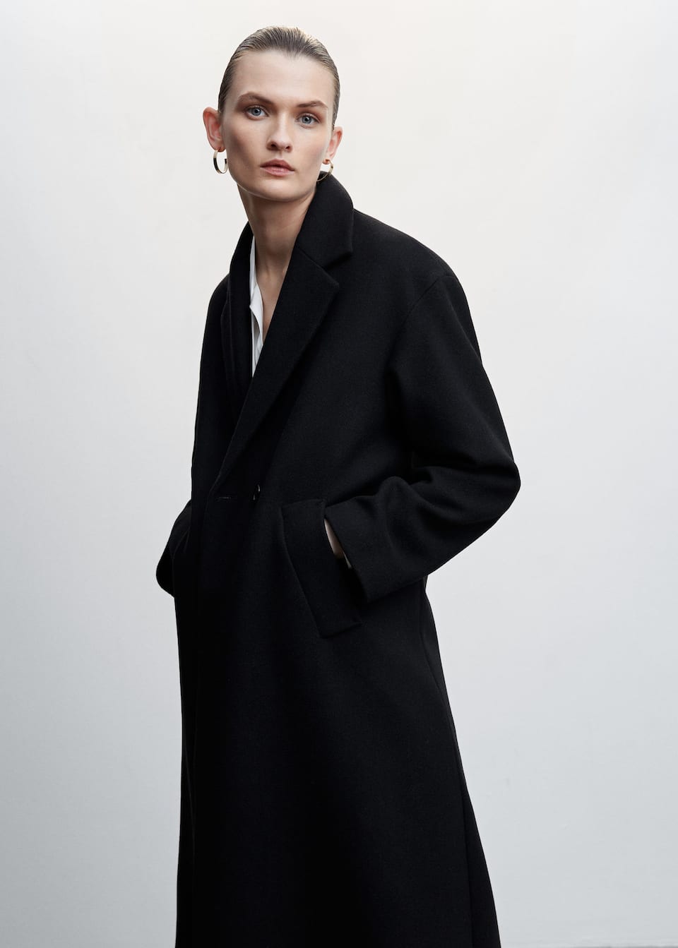 Mango oversized black wool coat in a wool mix. This midi design has an oversized fit, lapel-collar and two side pockets. Back-slit hem. Button fastening on the front section. Inner lining.