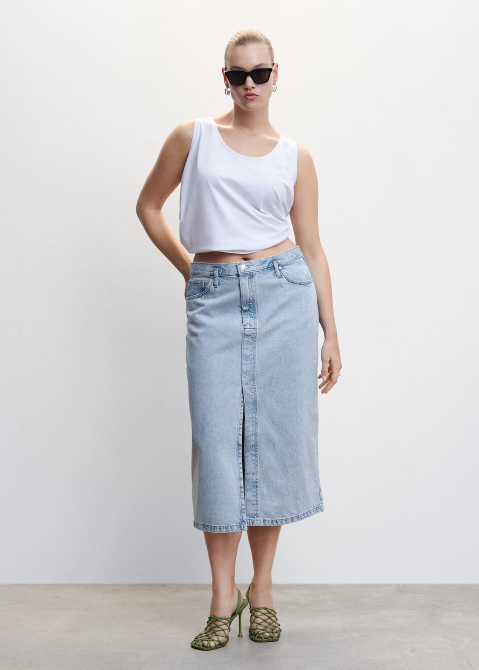 Mango denim midi skirt in a straight design with a high waist and slit at the front. Belt loops and single button and zip fastening. Traditional side pockets and back patch pockets.