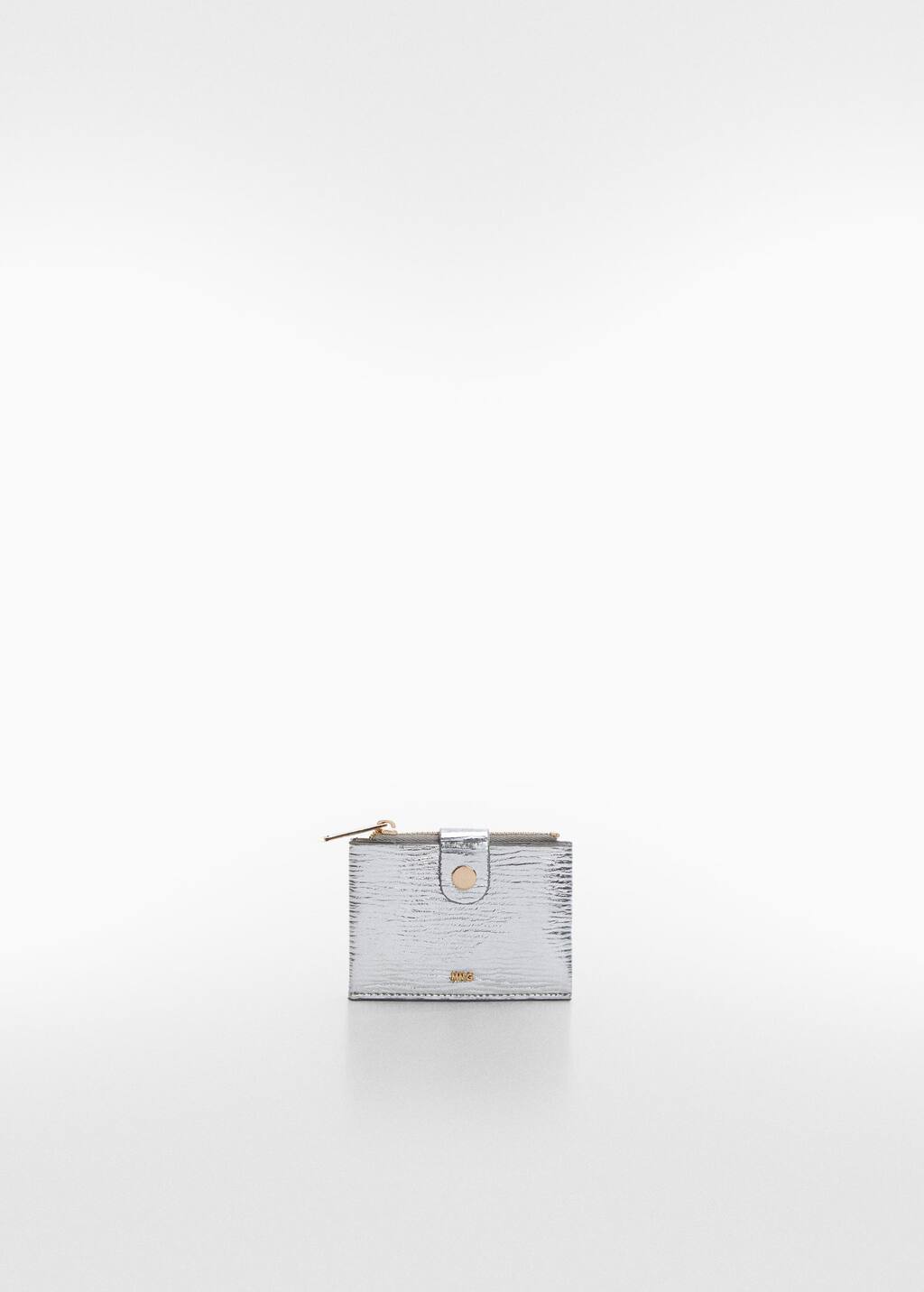 Mango Textured card holder with embossed logo. a silver purse sitting on top of a white table. 