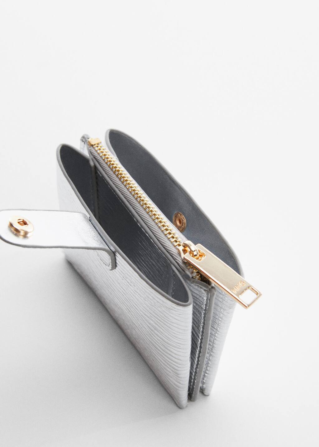 Mango Textured card holder with embossed logo. a close-up view of the inside of a silver purse. 