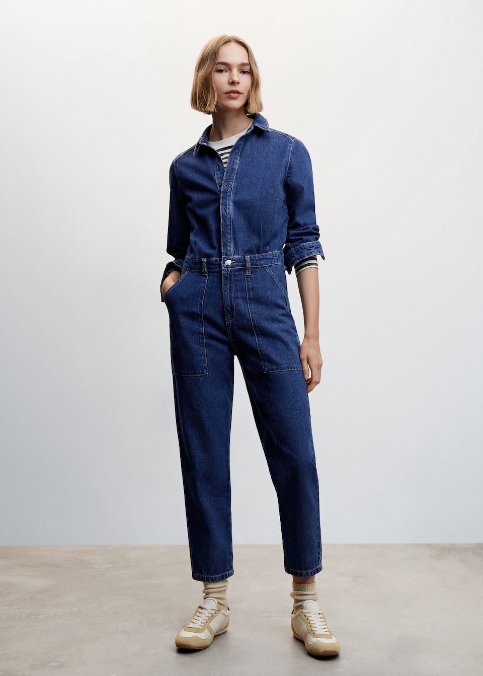 Mango blue denim jumpsuit with shirt collar, long sleeves and hidden button placket fastening at the front. Long sleeves with button fastening, belt loops and utility style patch pockets.