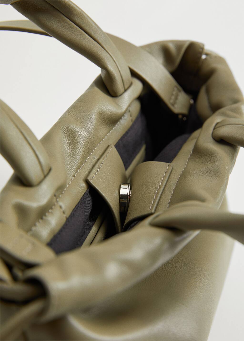 Mango Pleated volume bag. a close-up view of the inside of a purse. 